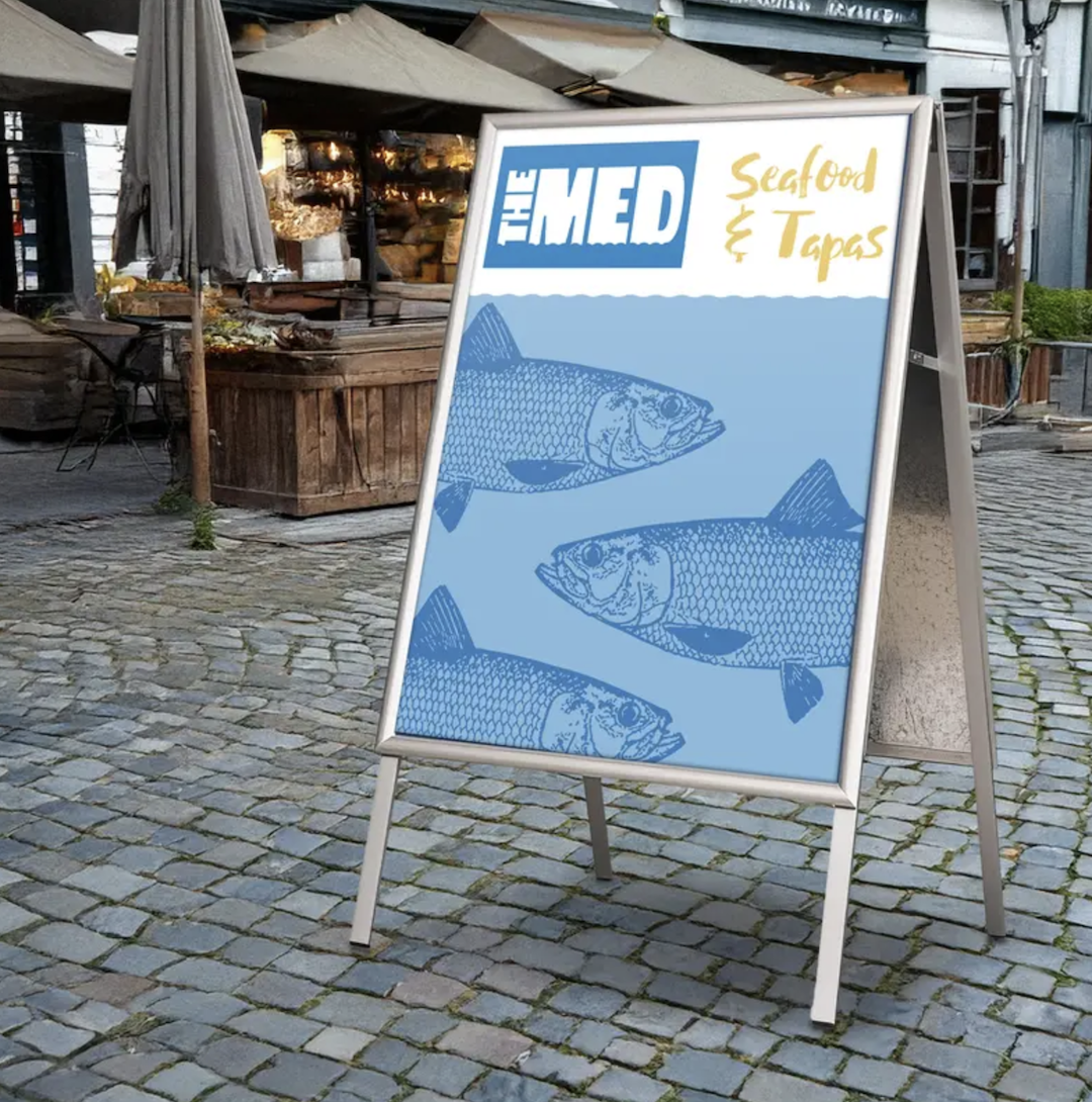 Seafood and tapas menu poster displayed on an outdoor A-frame board